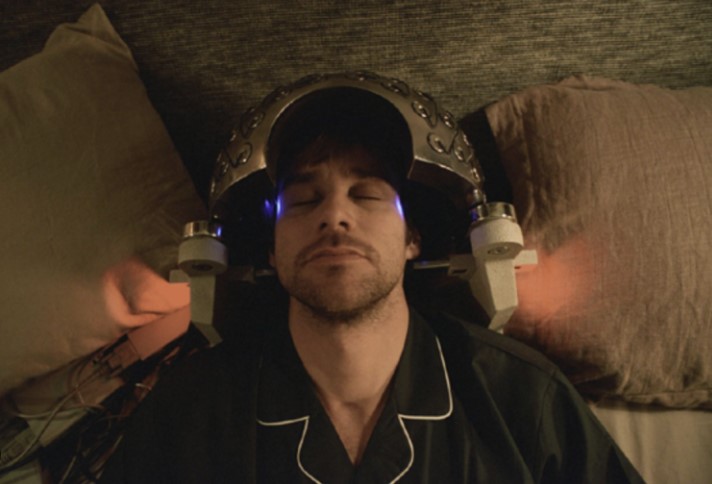 이터널 선샤인 기억 삭제 장면 – 조엘이 침대에 누워 락쿤 테크놀로지의 뇌파 헬멧을 쓴 채 기억 삭제 시술을 받고 있는 모습