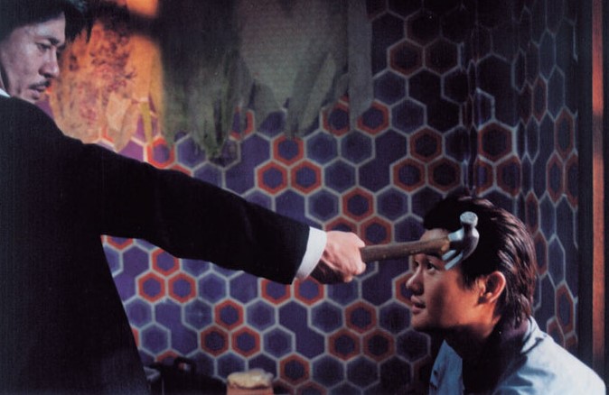 영화 올드보이에서 오대수가 이우진의 머리에 장도리를 대고 대립하는 긴장감 넘치는 장면