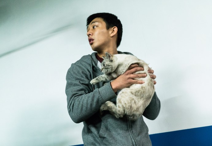 영화 버닝 스틸컷 — 벤의 집에서 해미의 고양이 보일을 발견하고 안고 있는 종수(유아인), 해미 실종의 결정적 단서 장면