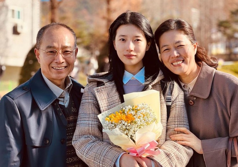 드라마 안나에서 주인공 유미가 대학 입학식을 가장해 부모님과 꽃다발을 들고 행복한 듯 기념사진을 찍는 장면