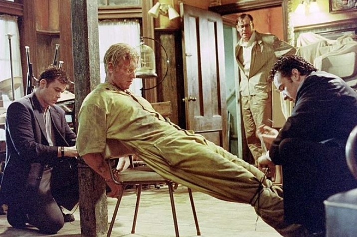 영화 아이덴티티 속 인물이 의자에 묶여 있는 긴장감 넘치는 스틸컷 장면