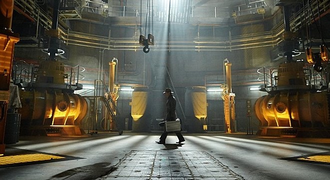 영화 타임 패러독스 중 거대한 기계 장치가 가득한 실험실 같은 공간을 걸어가는 요원의 모습