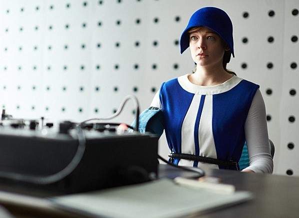 영화 타임 패러독스에서 파란색 제복을 입고 우주비행사 선발 시험에 임하고 있는 제인(사라 스누크)의 모습