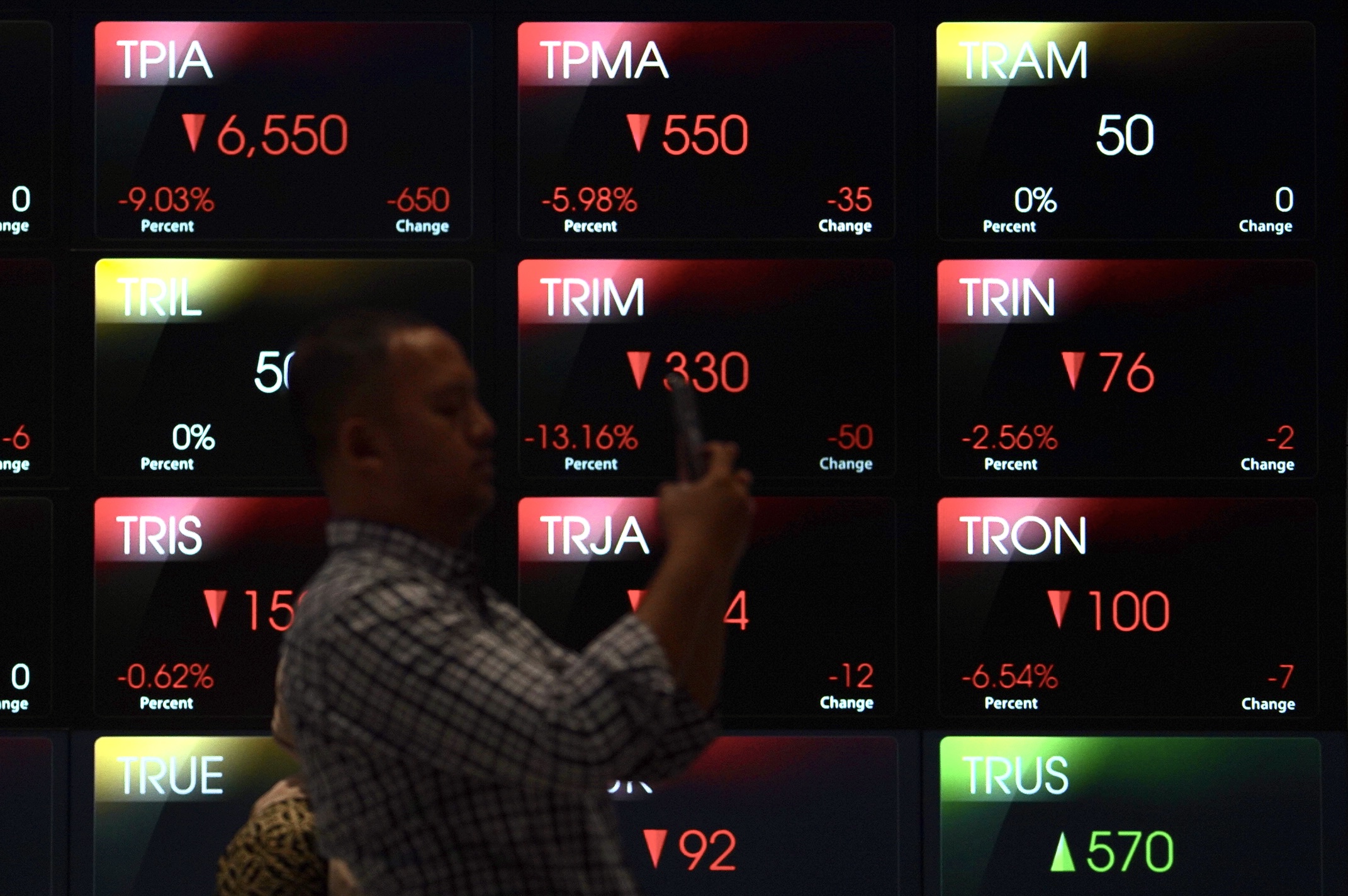 Pengunjung di depan layar yang menampilkan ilustrasi IHSG di Bursa Efek Indonesia (BEI), Jakarta