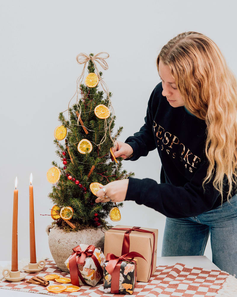 Woman decorating Spruce Tree 