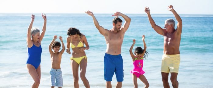 Happy family dancing on the beach