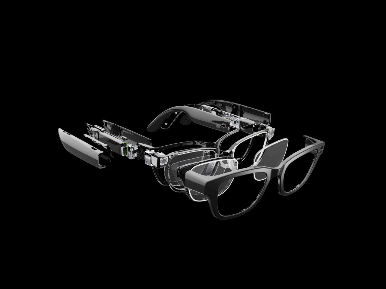 An exploded product schematic of a pair of black smart glasses on a black background, detailing the internal electronic circuitry, camera modules, and layered optical lenses.