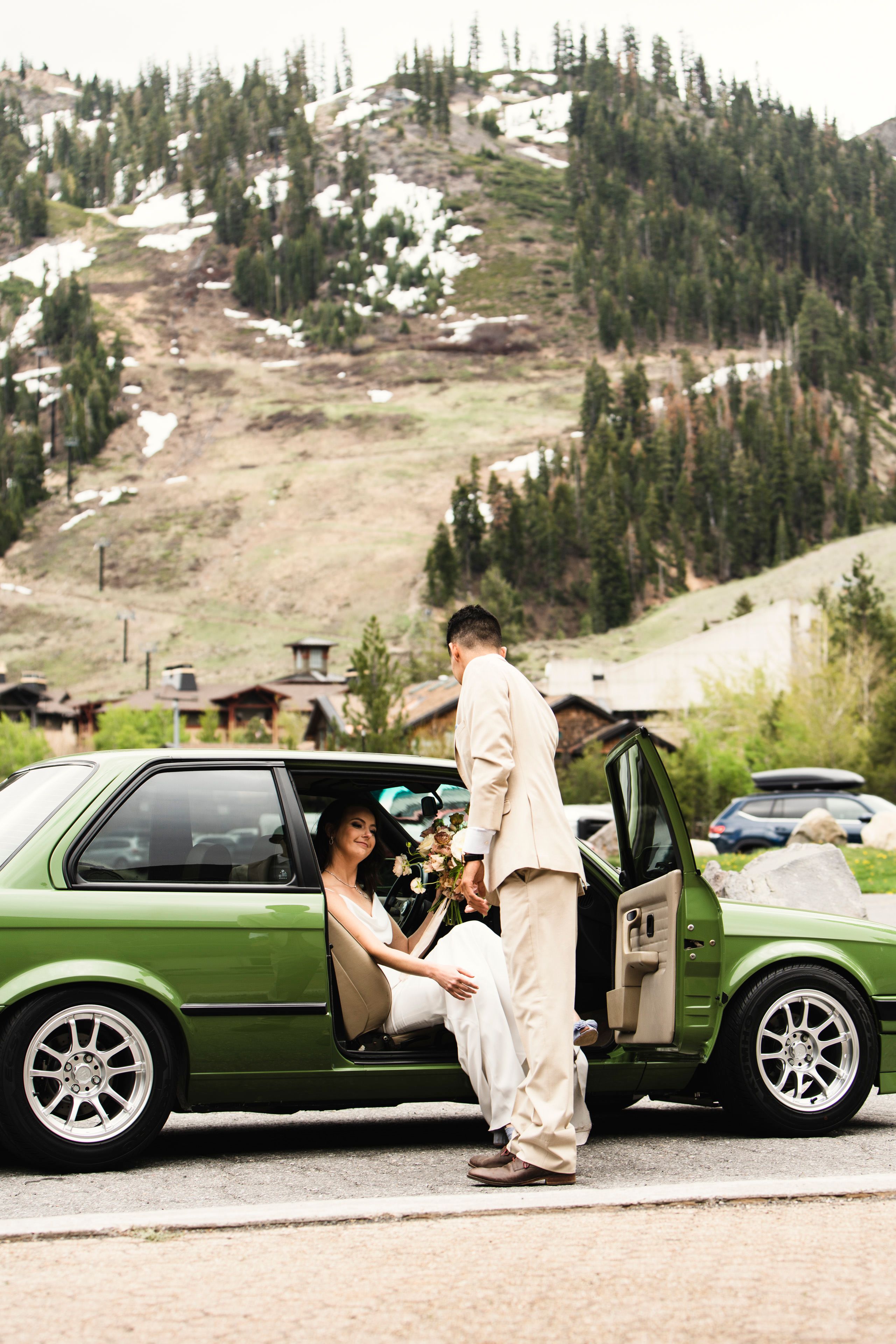 groom helping bride out of a green car | Amanda & Henry