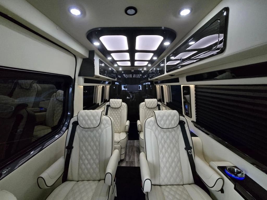 Light-colored Sprinter seats beneath white ceiling panels