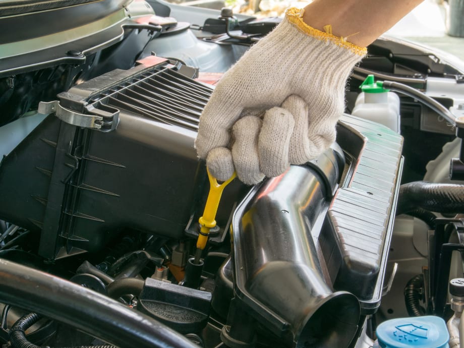 Technician checking fluid levels under the hood of a vehicle