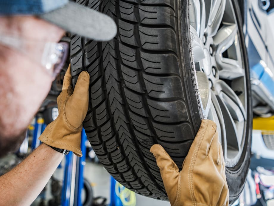 Technician servicing a tire in the All Access Automotive shop