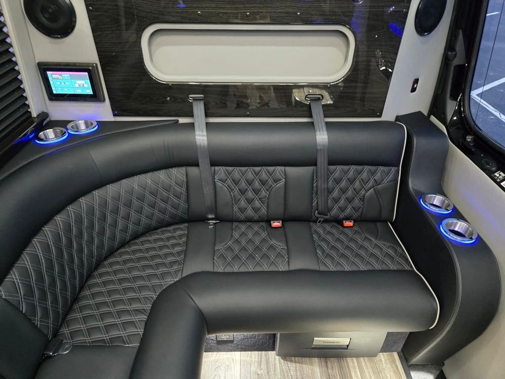 Luxury Mercedes-Benz Sprinter limo van interior with diamond-stitched leather seating and ambient lighting
