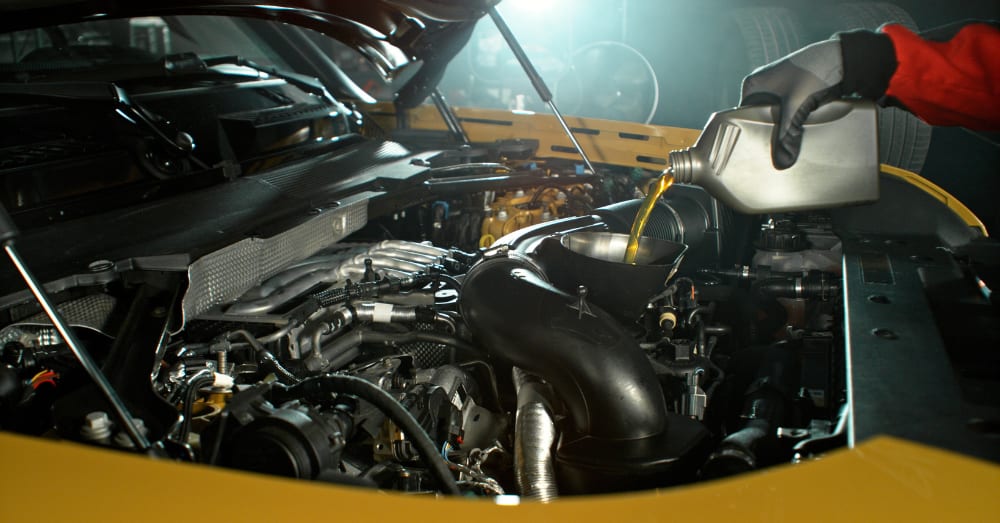 Technician checking engine oil during routine service
