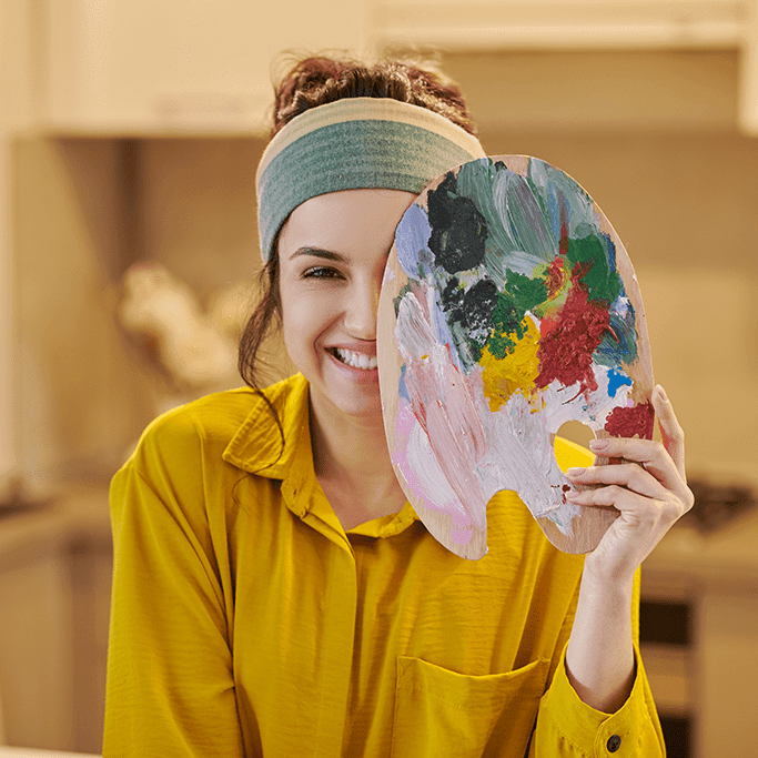 Woman happily holding a paint palette