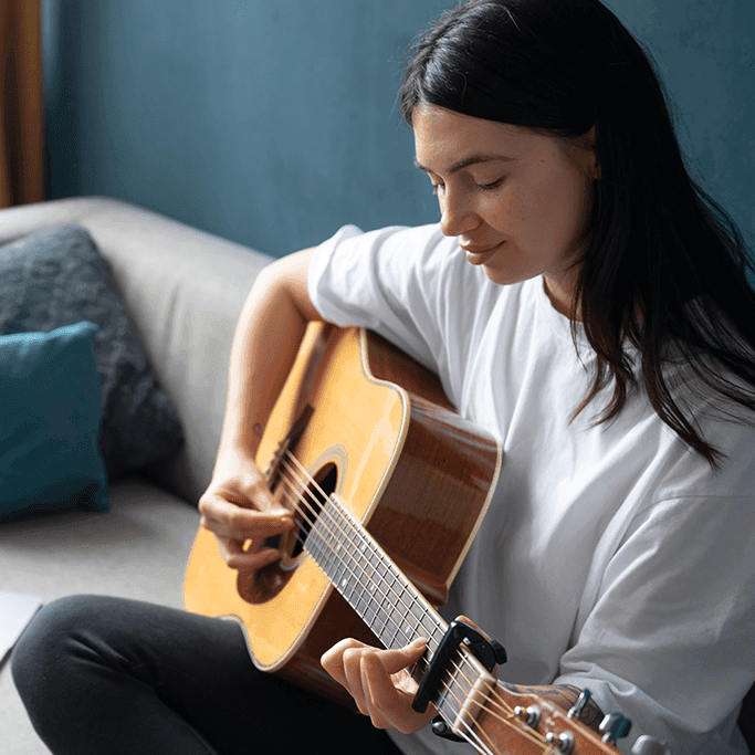 Woman calmly playing a guitar