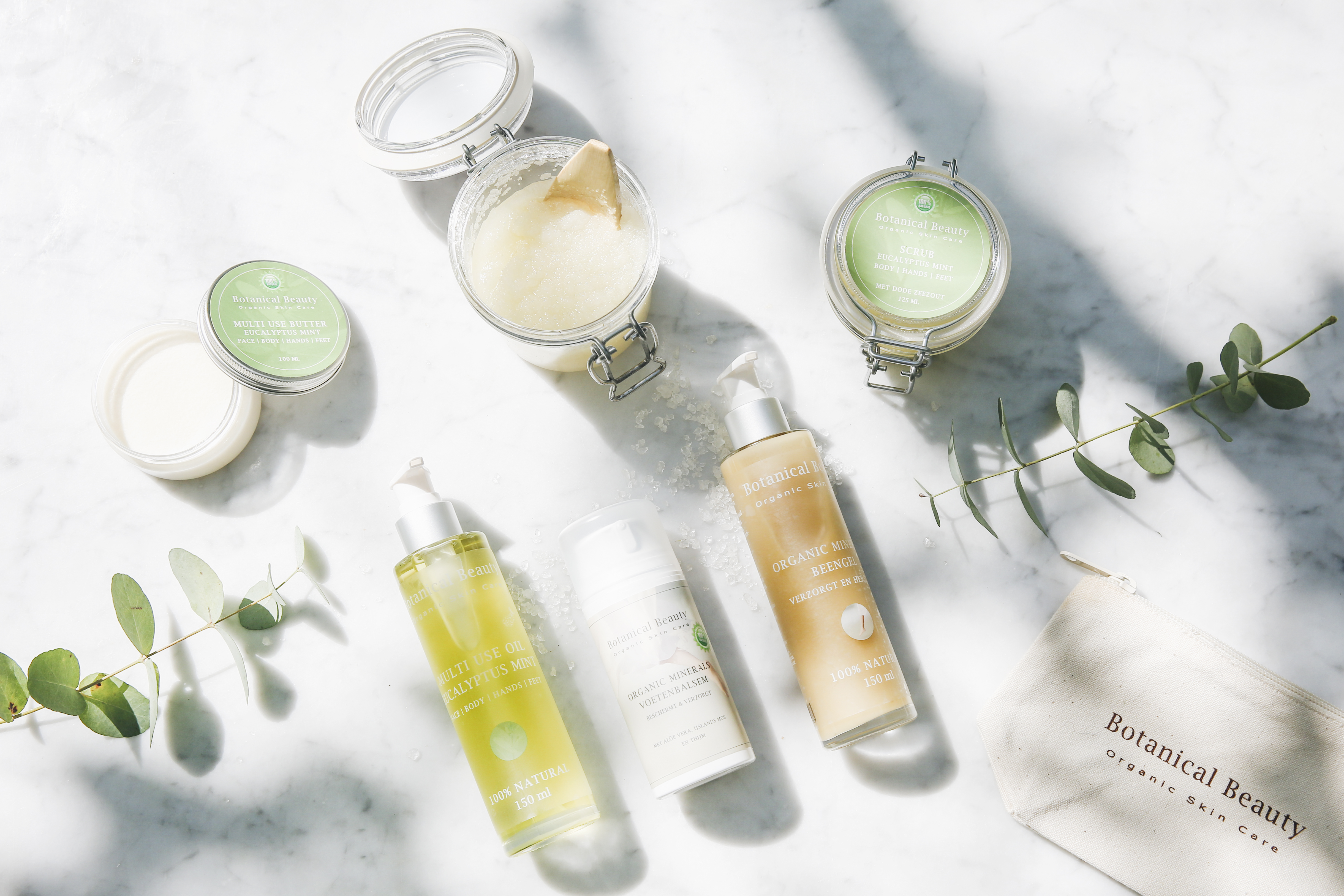Botanical Beauty oliën, scrub en body butter op wit marmer