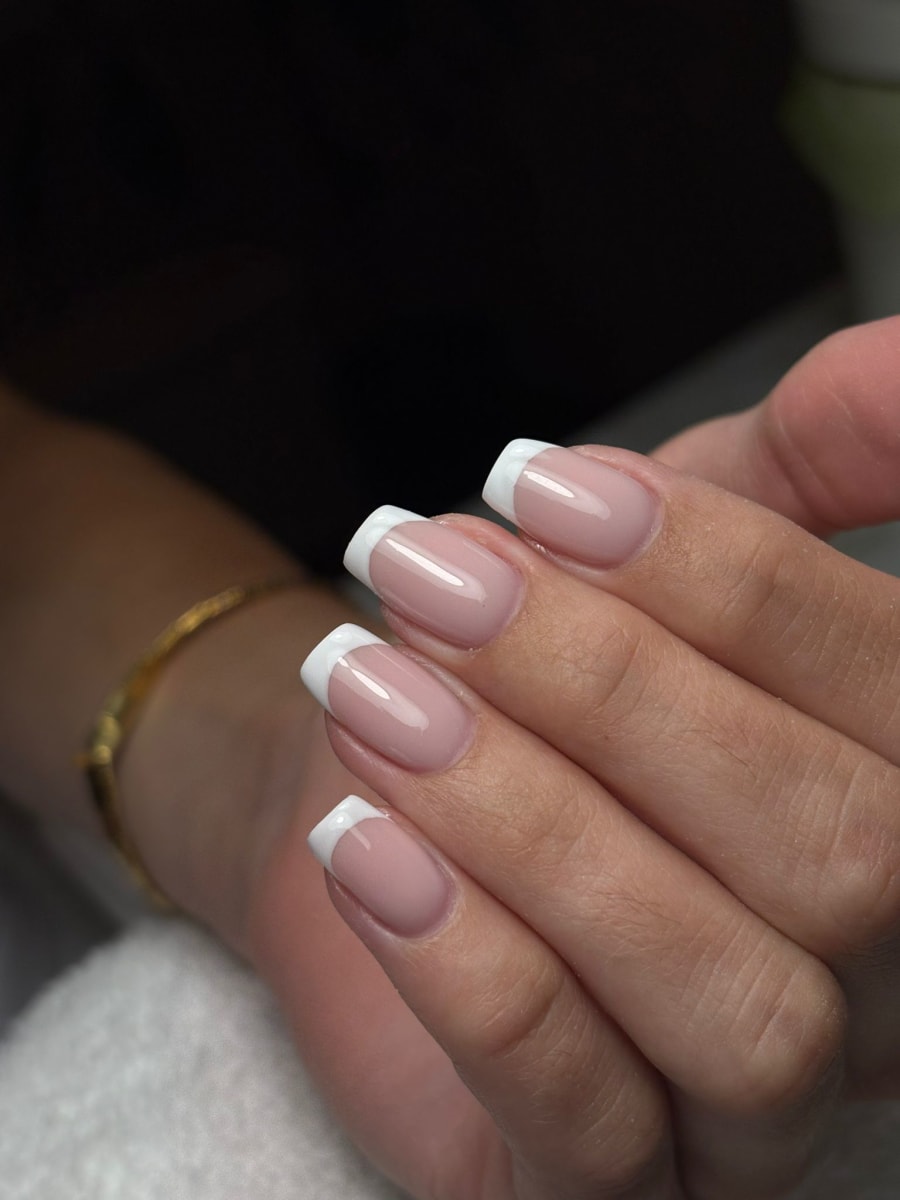 Verzorgde vierkante nagels met een klassieke witte French en glanzende finish