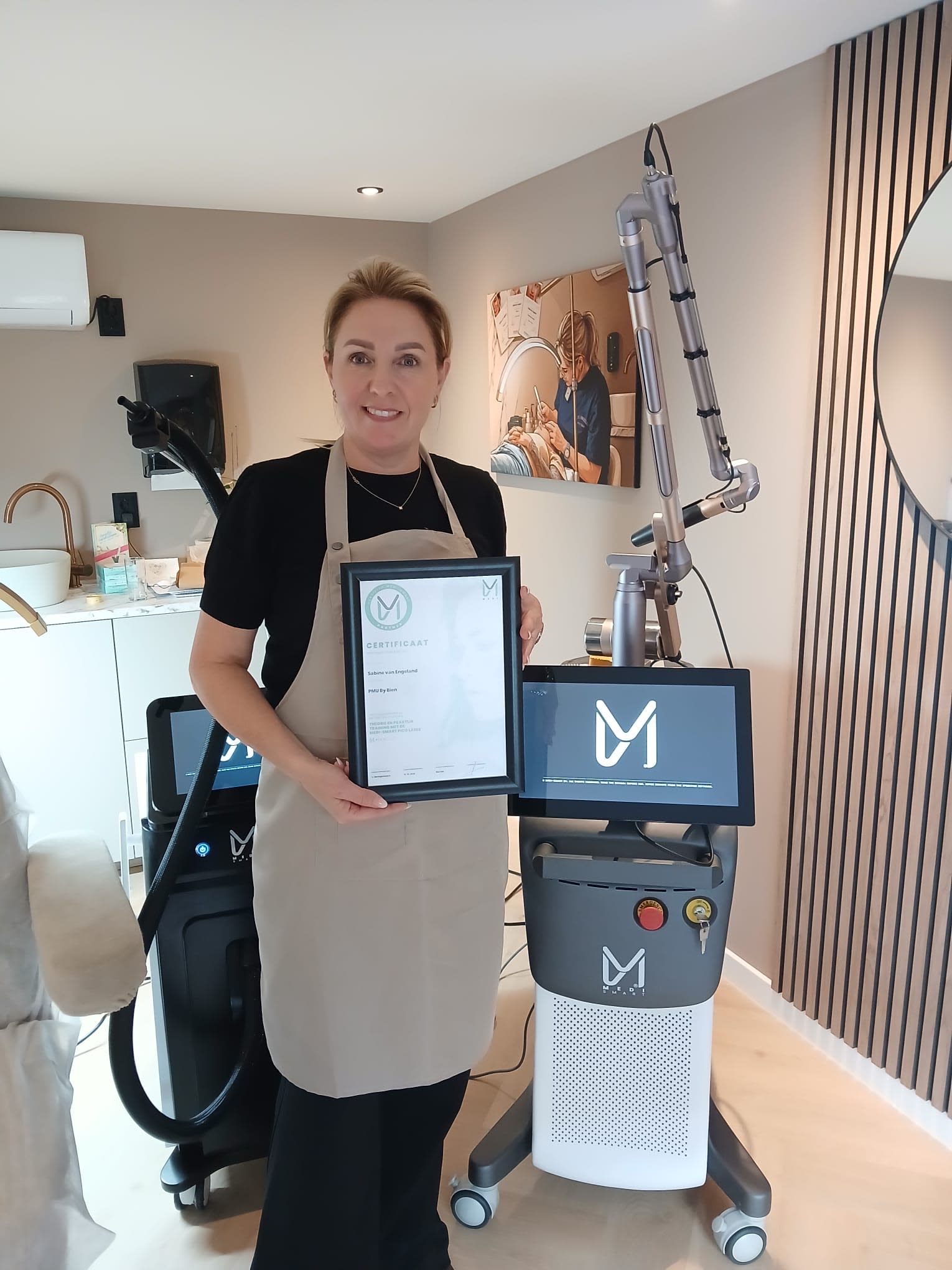 Sabine van Engeland in haar salon met een certificaat en de Pico Laser