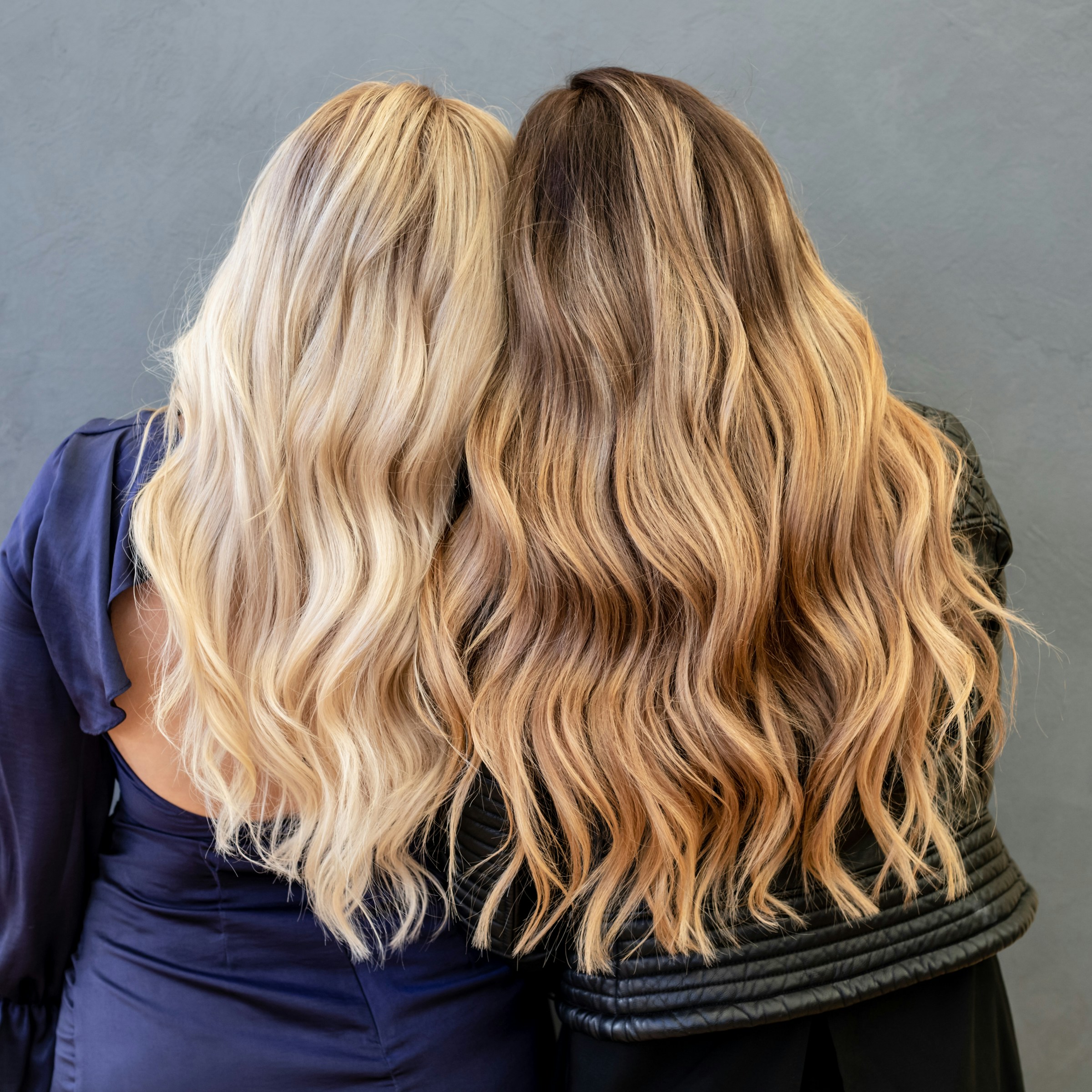 Twee vrouwen met lang, golvend blond en bruin gekleurd haar