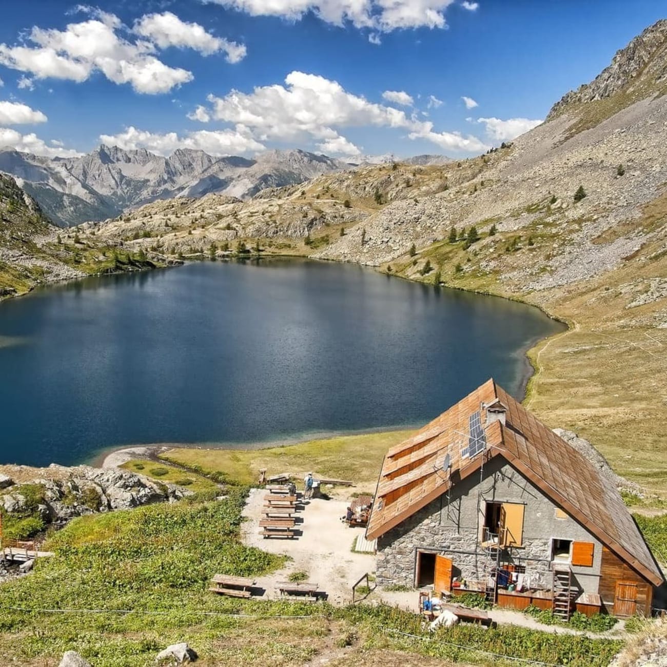 Randonnée Mercantour : refuge devant lac au creux des montagnes