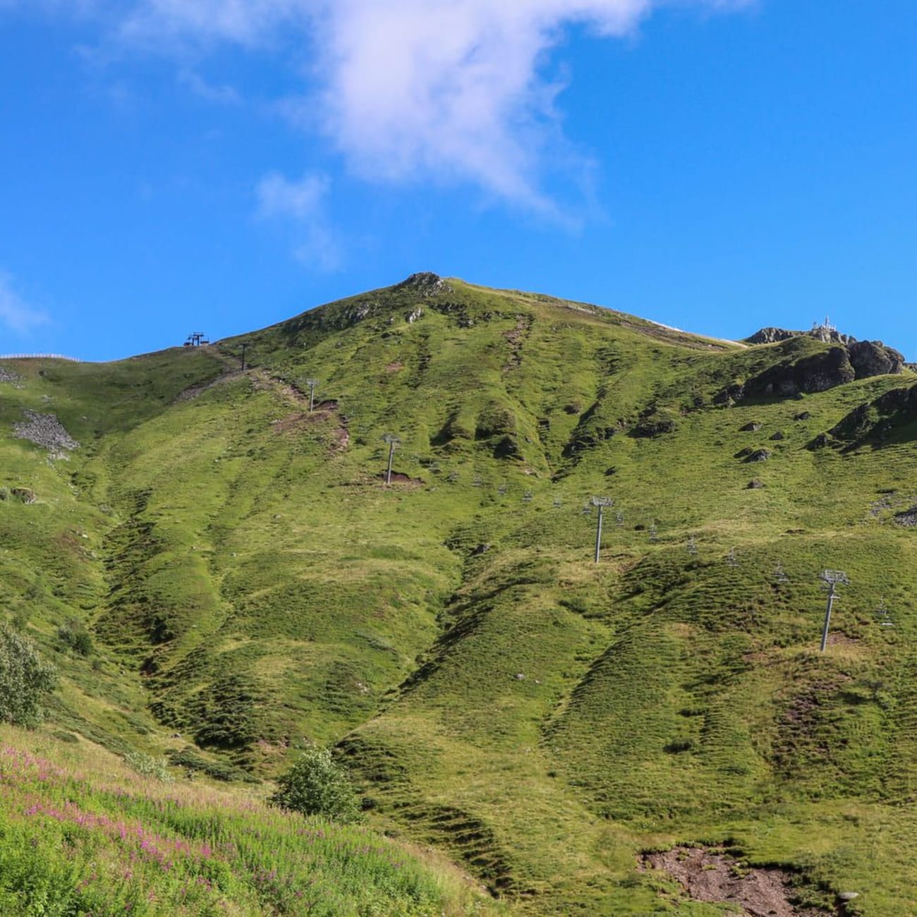 Randonnée monts du Cantal : sommet pointu verdoyant sous ciel bleu