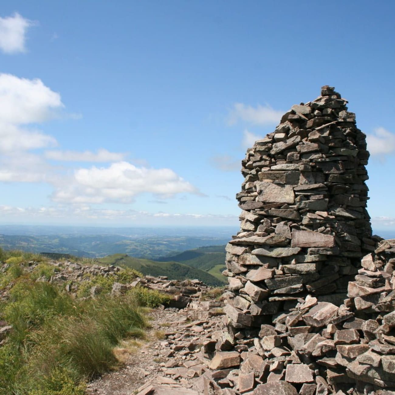 Randonnée monts du Cantal : haut tas de pierres sur sommet de montagne