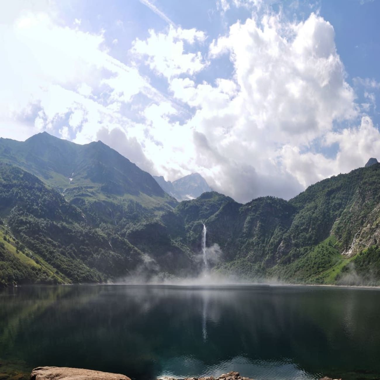 Randonnée lac d'Oô : étendue d'eau plate et brume au pied d'une cascade