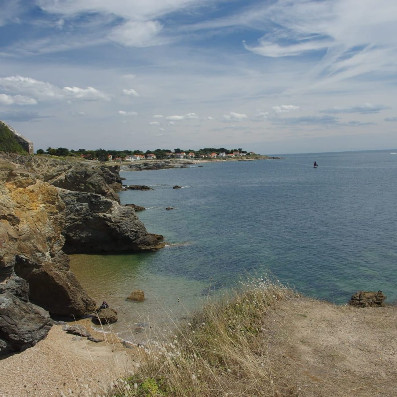 Randonnée pointe Saint-Gildas : petite plage de sable entourée de falaises rocheuses au bord de l'océan turquoise