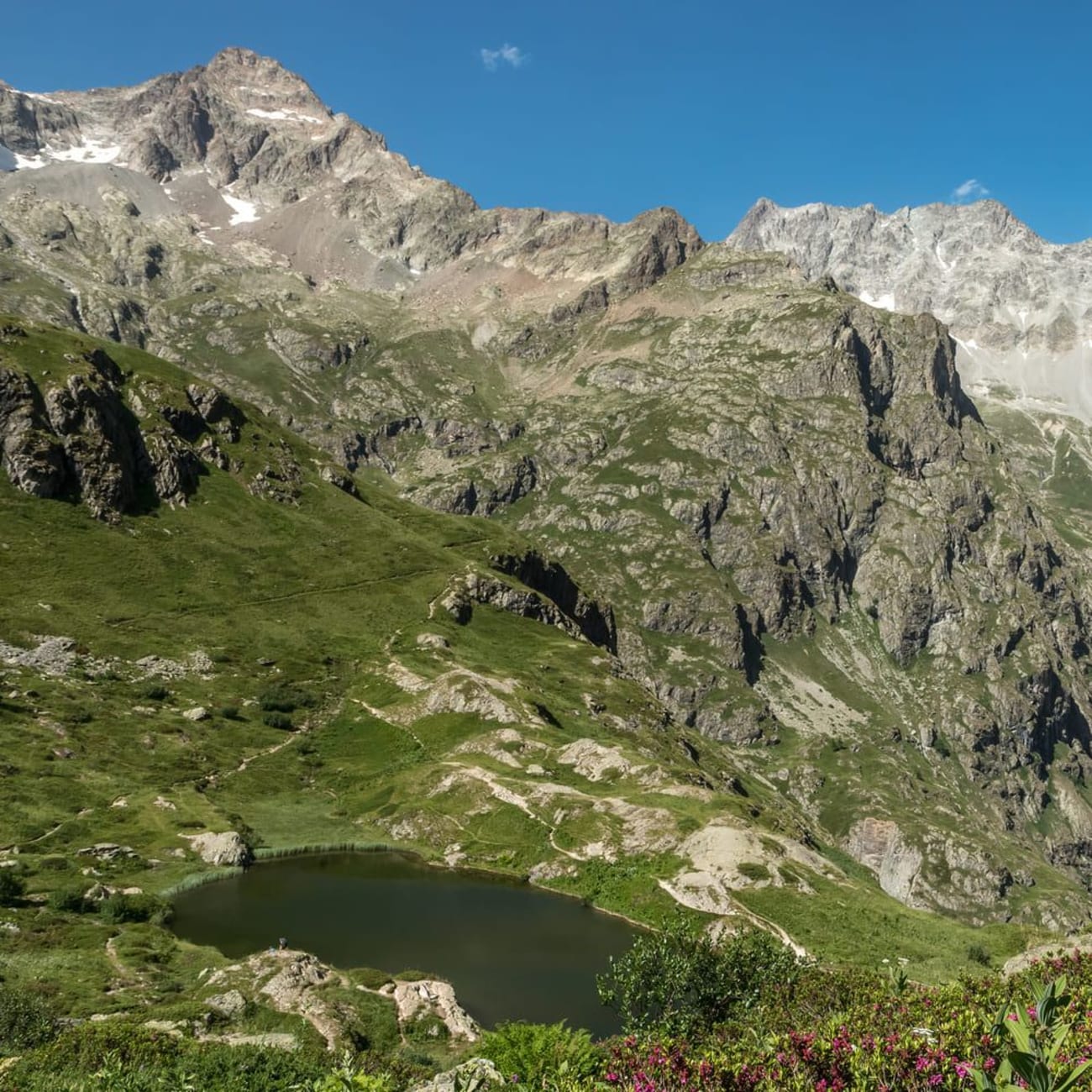 Randonnée lac du Lauzon : étendue d'eau au pied de montagnes verdoyantes et fleurs