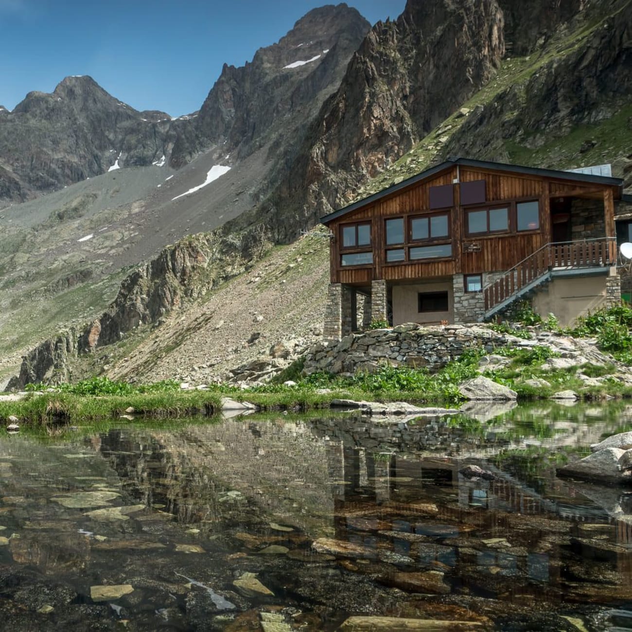 Randonnée lac du Lauzon : chalet au bord d'une étendue d'eau au pied des montagnes