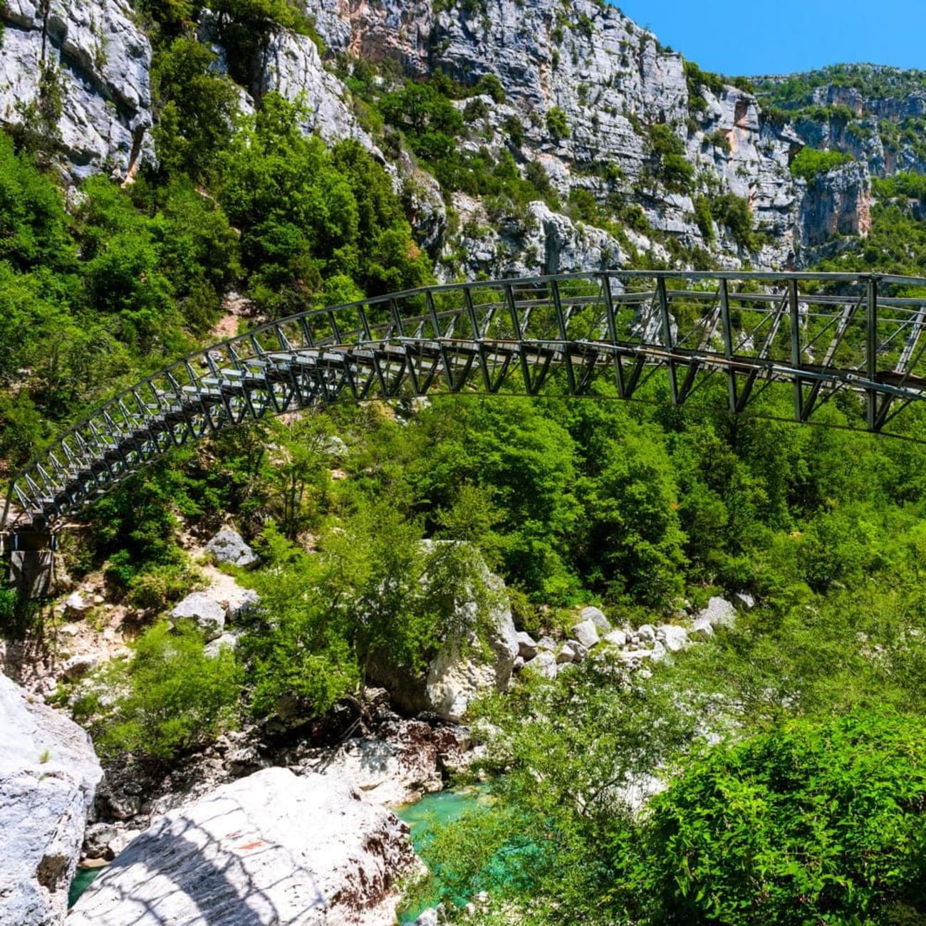 Randonnée sentier Blanc Martel : passerelle en métal passant au-dessus de l'eau serpentant entre les roches