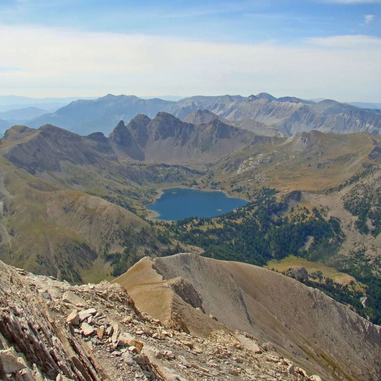 Randonnée Mercantour : vue plongeante sur étendue d'eau entourée de montagnes rocheuses
