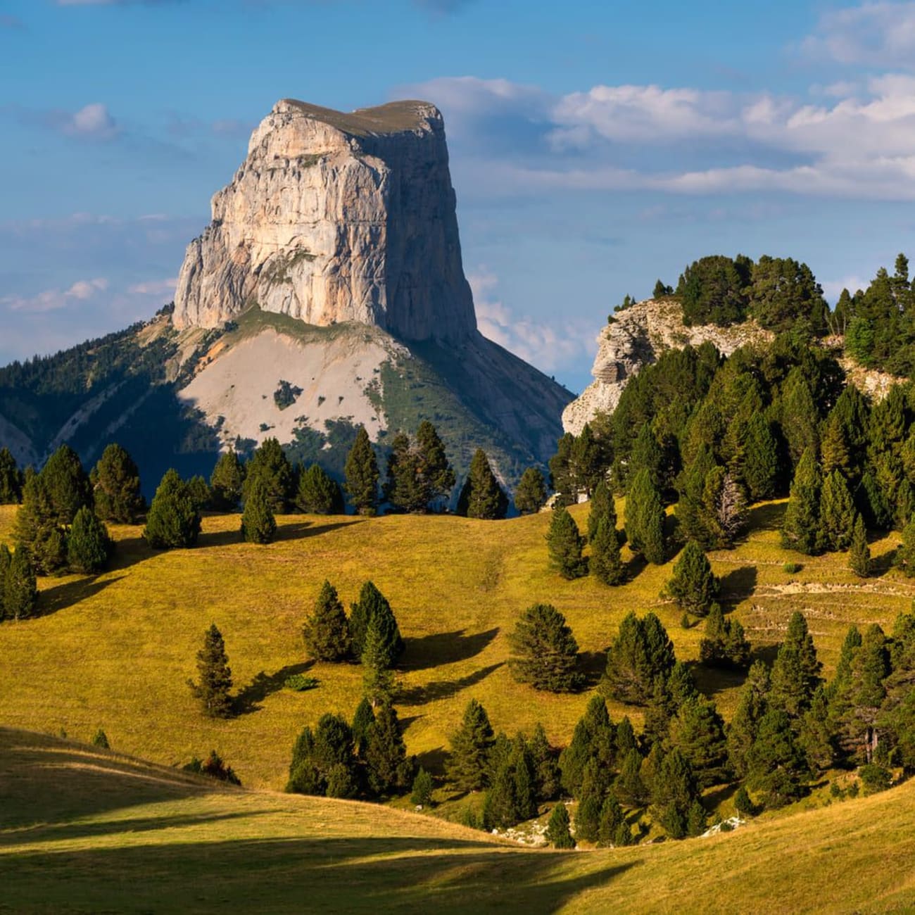 Randonnée Vercors : montagne rocheuse cylindrique et plateau vallonné verdoyant