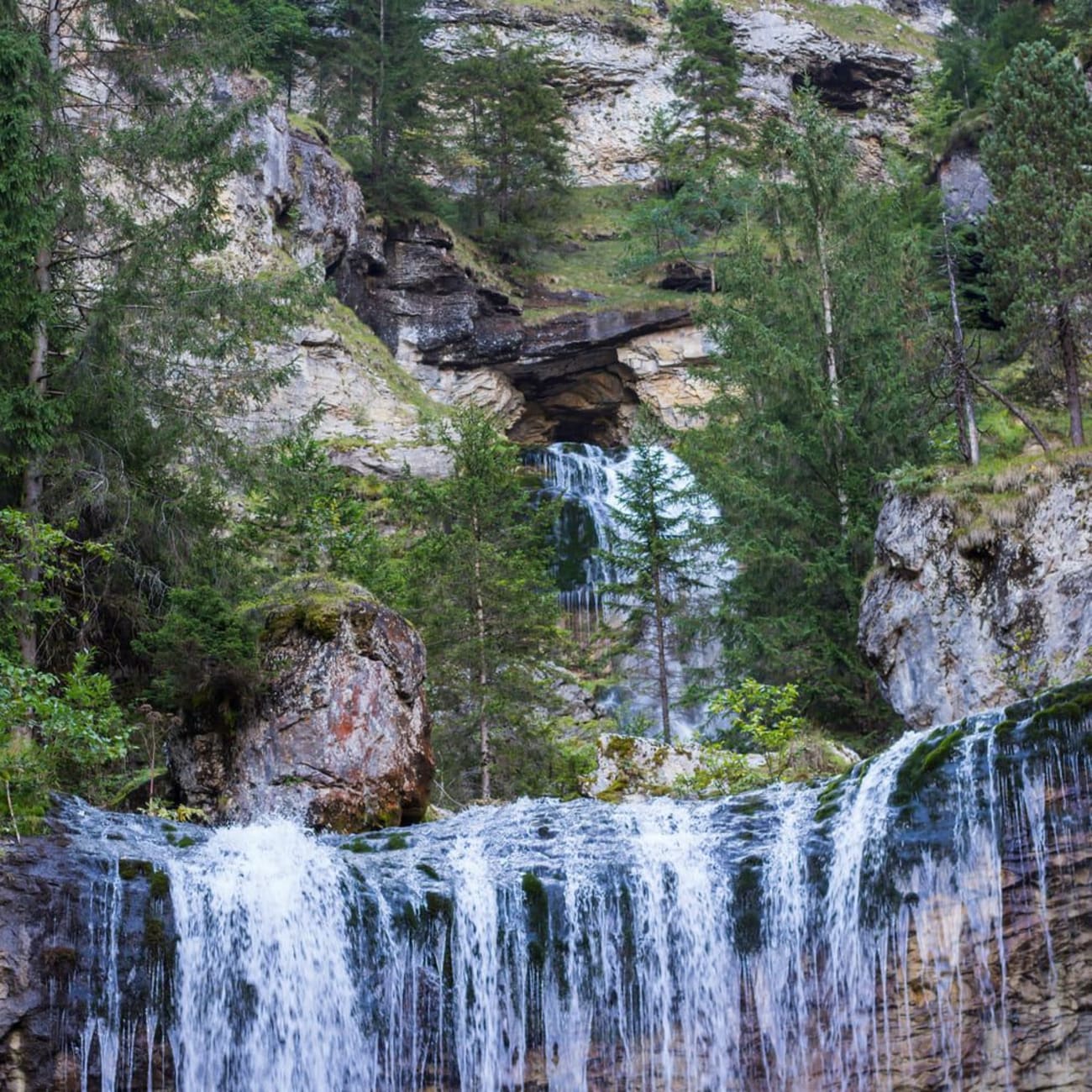 Randonnée cirque de Saint-Même : chute d'eau ruisselant sur roche, entourée d'arbres