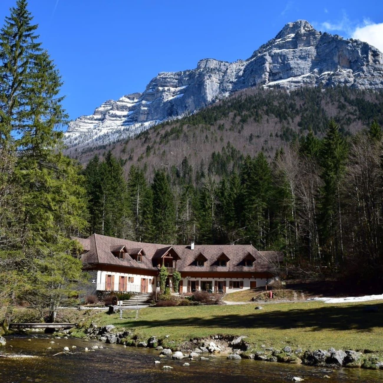 Randonnée cirque de Saint-Même : grande maison entourée d'une rivière, de pelouse, d'arbres et de montagnes