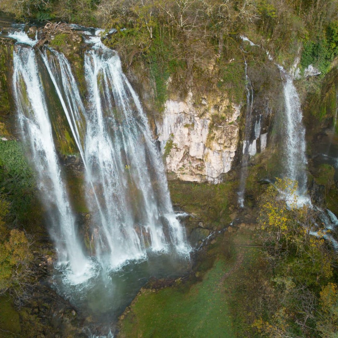 Randonnée cascades Ain : grandes chutes d'eau sur roche entourées de végétation