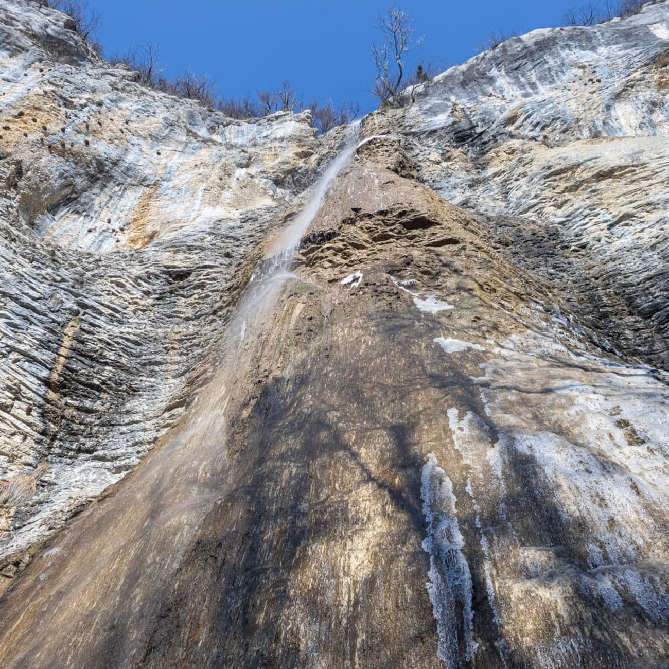 Randonnée cascades Ain : filet d'eau sur roche, vu du bas