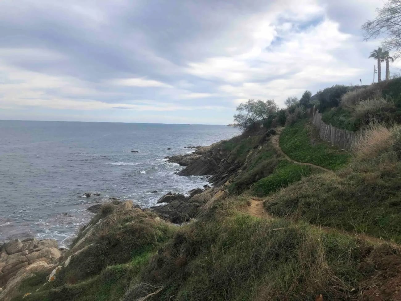 Randonnée au sentier du littoral Saint-Tropez : chemin serpentant dans l'herbe face à la mer