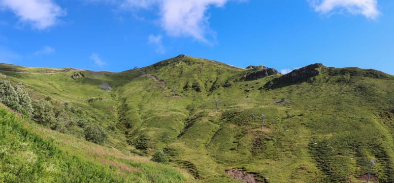 Randonnée Plomb du Cantal : sommet montagneux verdoyant sous ciel bleu