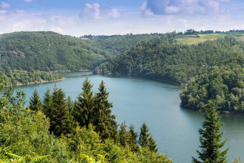 Randonnée lac Cantal : vue sur un lac entre deux collines boisées