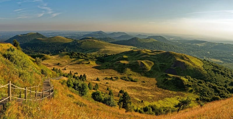 Randonnée chaine des Puys : vue sur les volcans d'Auvergne depuis le puy de Dôme, au lever du soleil