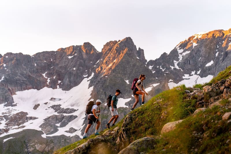 Randonnée au mont Buet : 3 randonneurs avec des sommets enneigés en arrière-plan