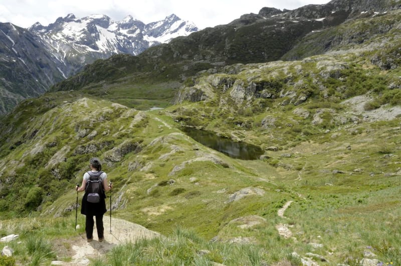 Randonnée lac du Lauzon : randonneuse sur sentier au milieu des montagnes verdoyantes