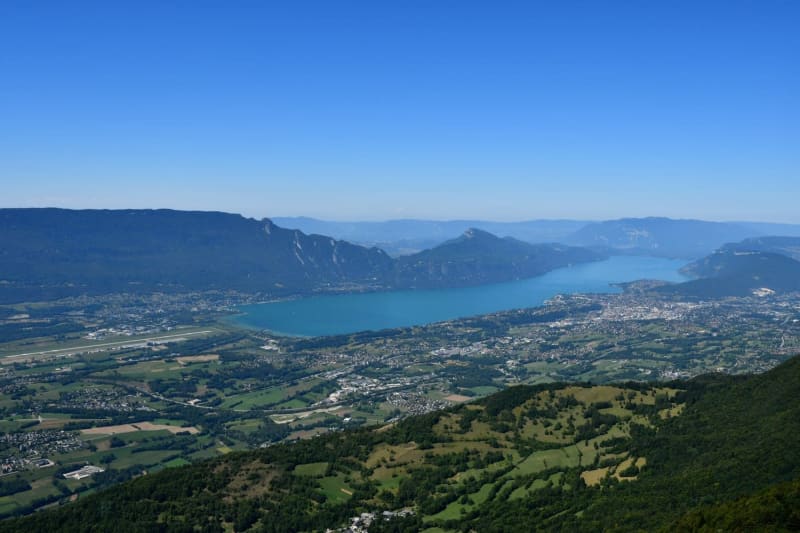 Randonnée Chambéry : grand lac turquoise entouré de plaines et de montagnes vertes et d'habitations