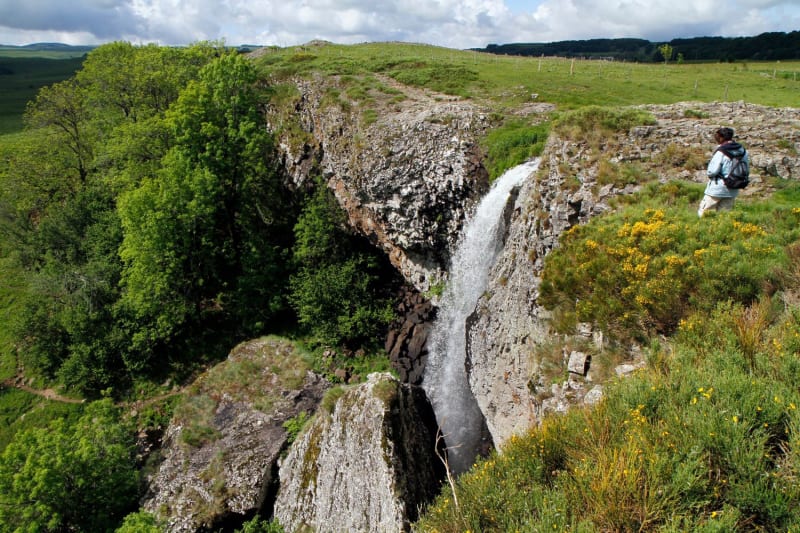 Randonneur passant à proximité de la cascade du Déroc sur le plateau de l'Aubrac.