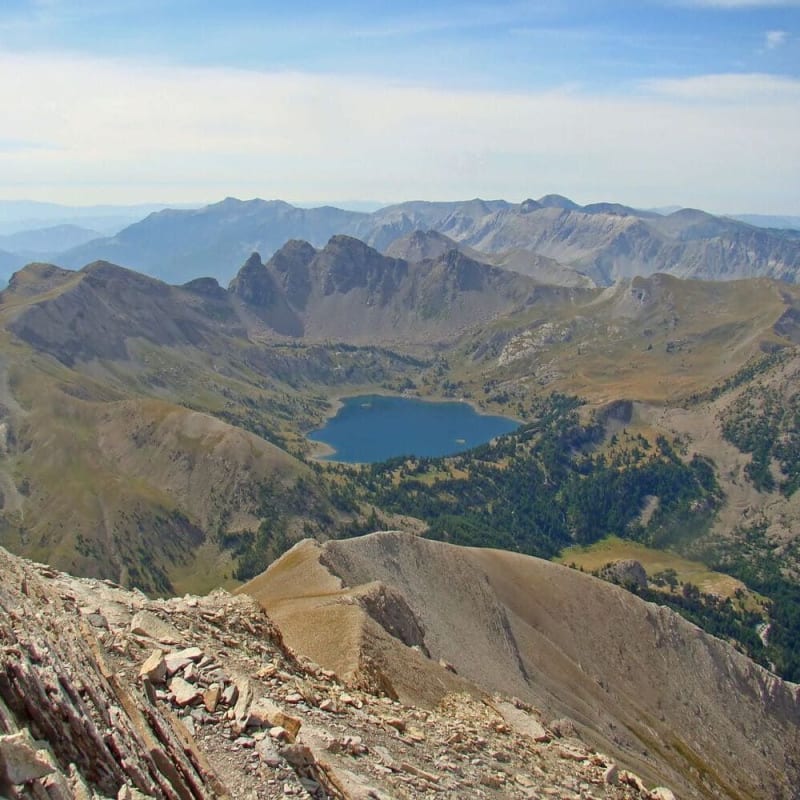 Randonnée Mercantour : vue plongeante sur étendue d'eau entourée de montagnes rocheuses