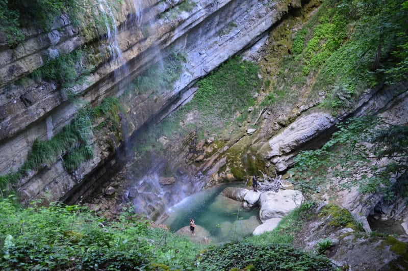 Randonneuse sous une cascade dans le torrent de l'Alloix.