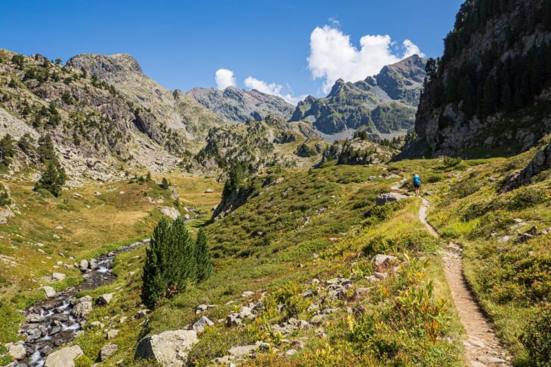 Randonnée Belledonne : un sentier dans une vallée, entre une rivière et des sommets rocailleux