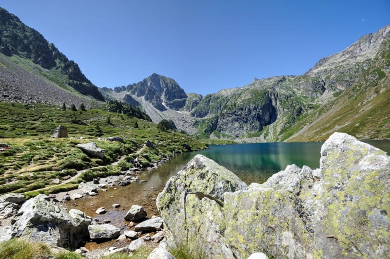 Randonnée lac d'Ilhéou : vue sur le lac au printemps, derrière des rochers