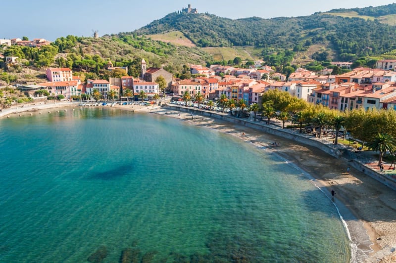 Randonnée Collioure : baie avec eau bleue, maisons aux toits orangés et collines vertes en fond